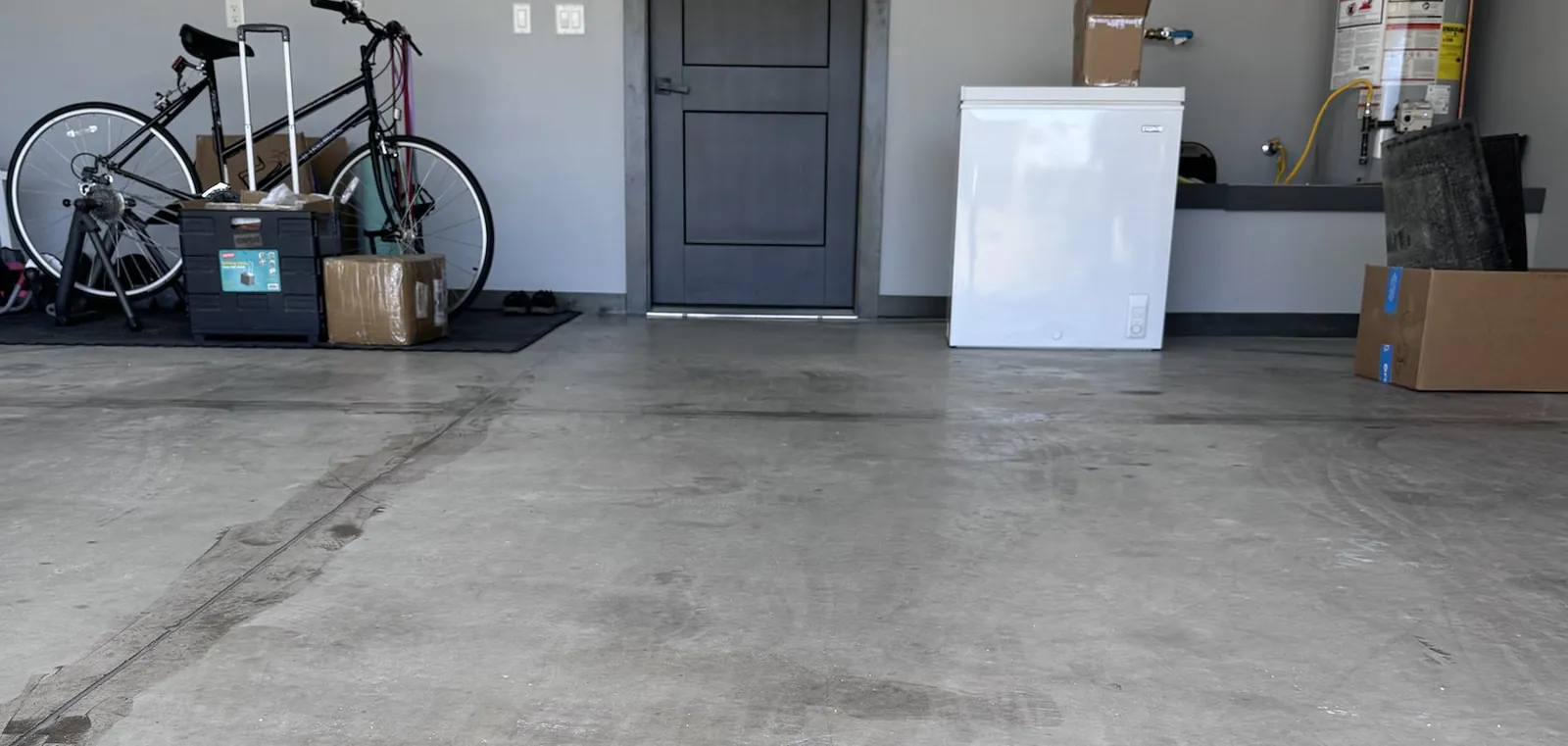 A stained bare concrete garage floor before Capepoxy